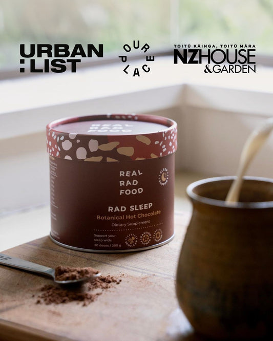 Real Rad Food Rad Sleep sleepy hot chocolate featured in Urban List, NZ House & Garden and Our Place magazine beside a warm mug of sleepy hot chocolate